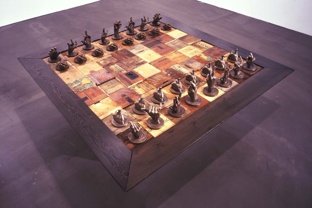  | Selected Works | Glenn Kaino, The Burning Boards (performance documentation photograph, detail), 2007, 16 wood chessboards, wax chess pieces, 32 players, Dimensions variable, Courtesy of the artist | 37